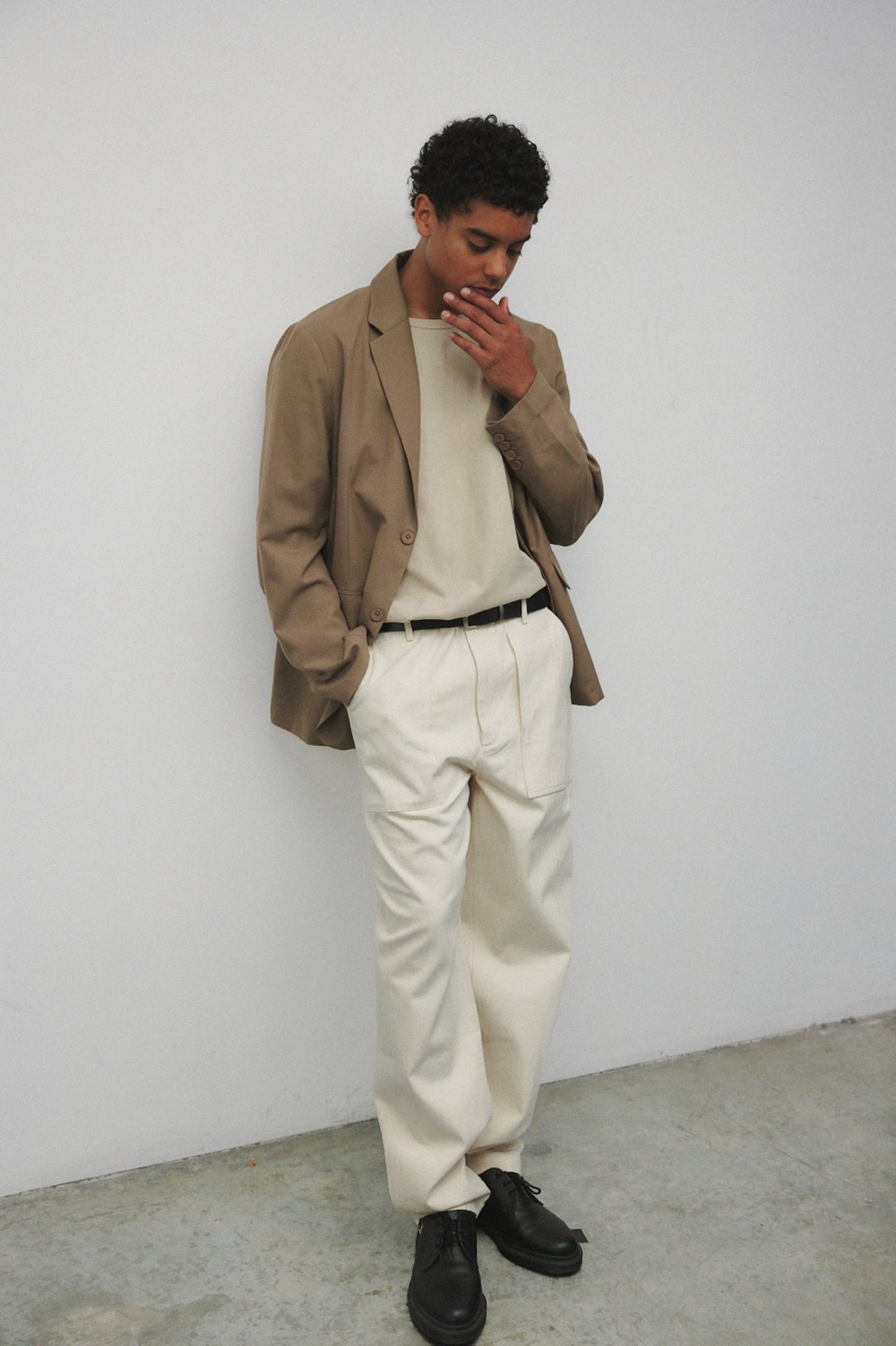 Model wearing bone elias top with cream pants, black oxfords, and khaki blazer
