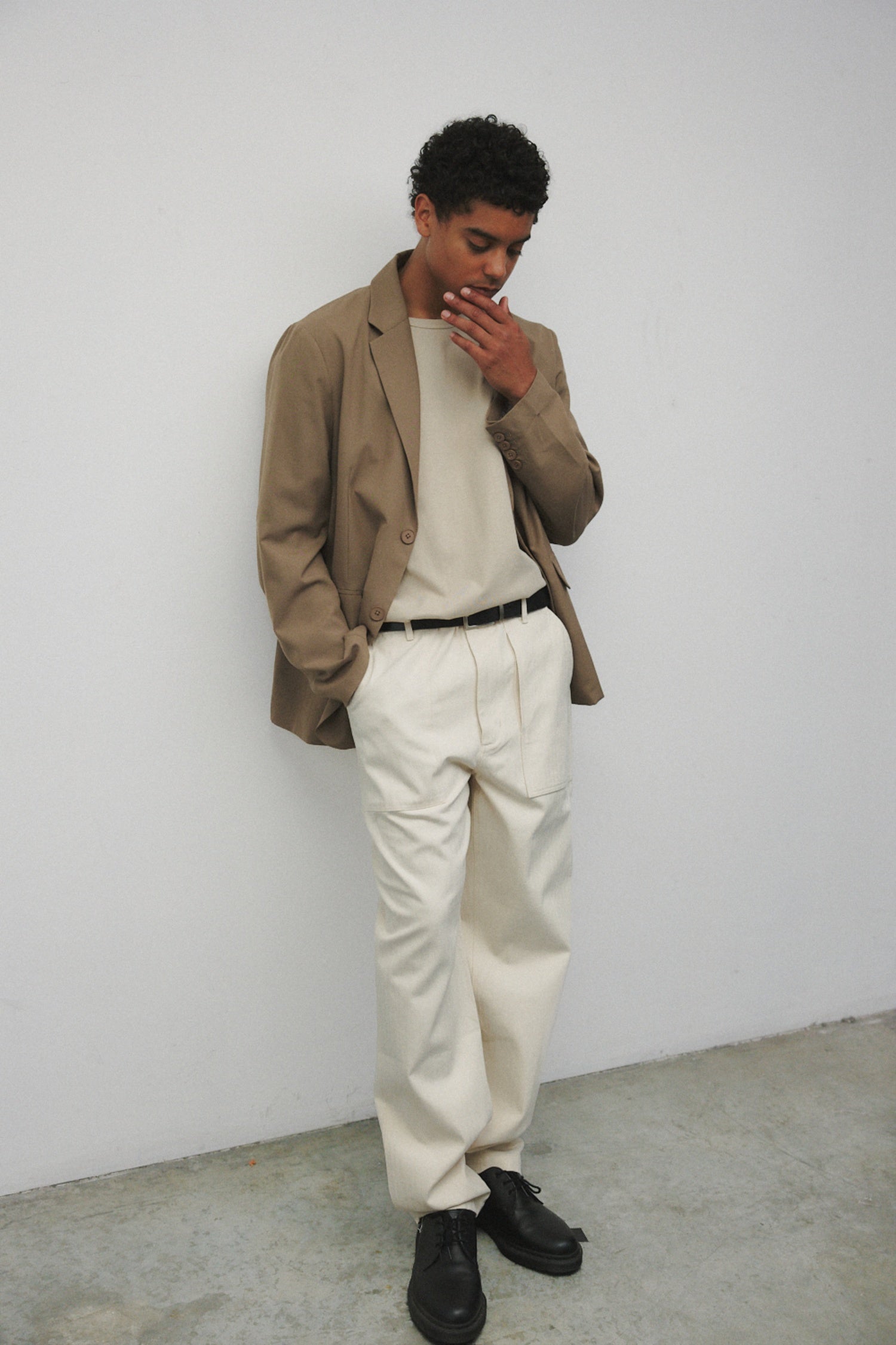 Model wearing bone elias top with cream pants, black oxfords, and khaki blazer