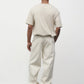 Model wearing bone elias top with cream pants and black oxfords, back view