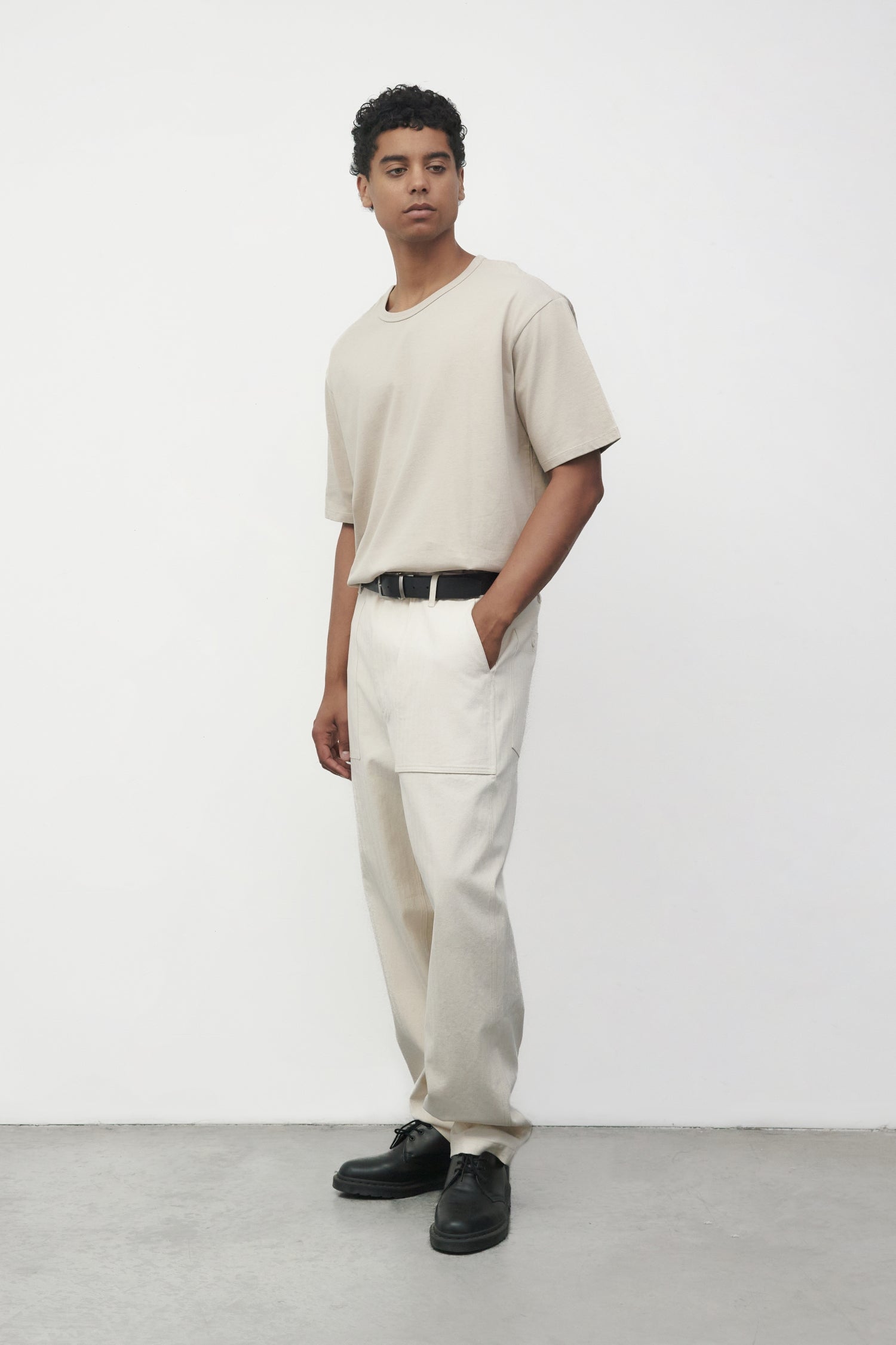 Model wearing bone elias top with cream pants and black oxfords, side view