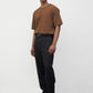 Model wearing brown elias top with black trousers and black boots, side view