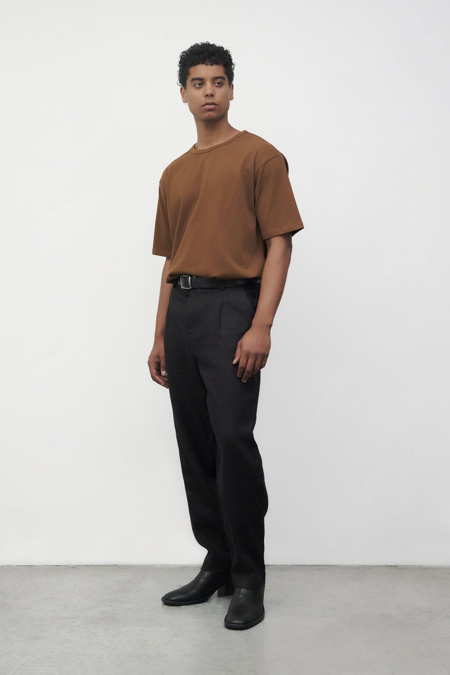 Model wearing brown elias top with black trousers and black boots, side view