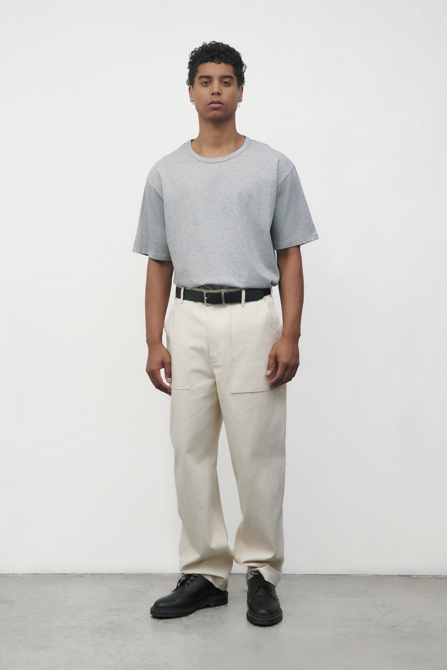 Model wearing heather grey elias top with cream pants and black oxfords