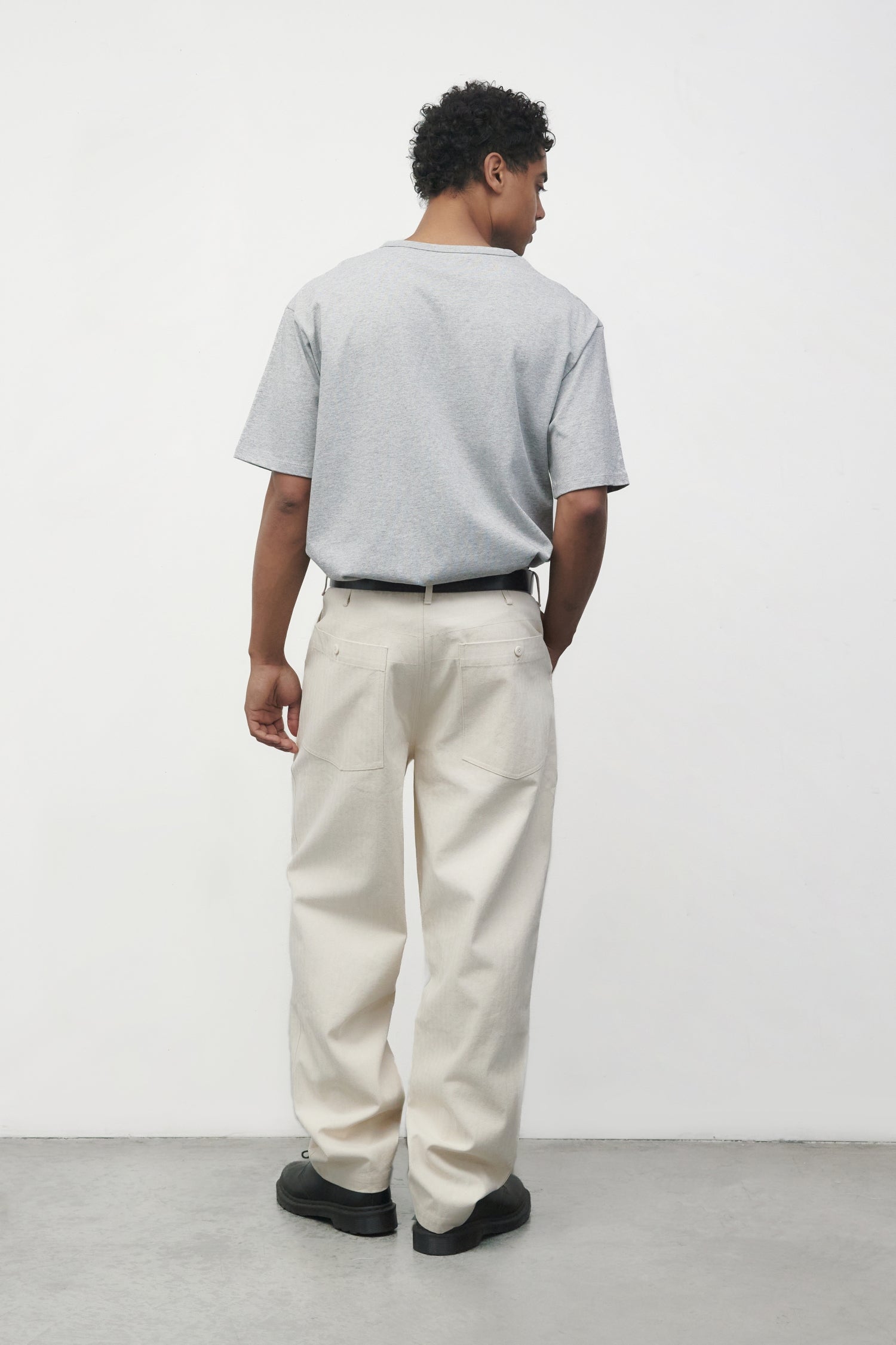 Model wearing heather grey elias top with cream pants and black oxfords, back side