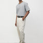 Model wearing heather grey elias top with cream pants, side view