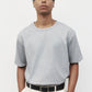 Model wearing heather grey elias top with trousers and black loafers, close up