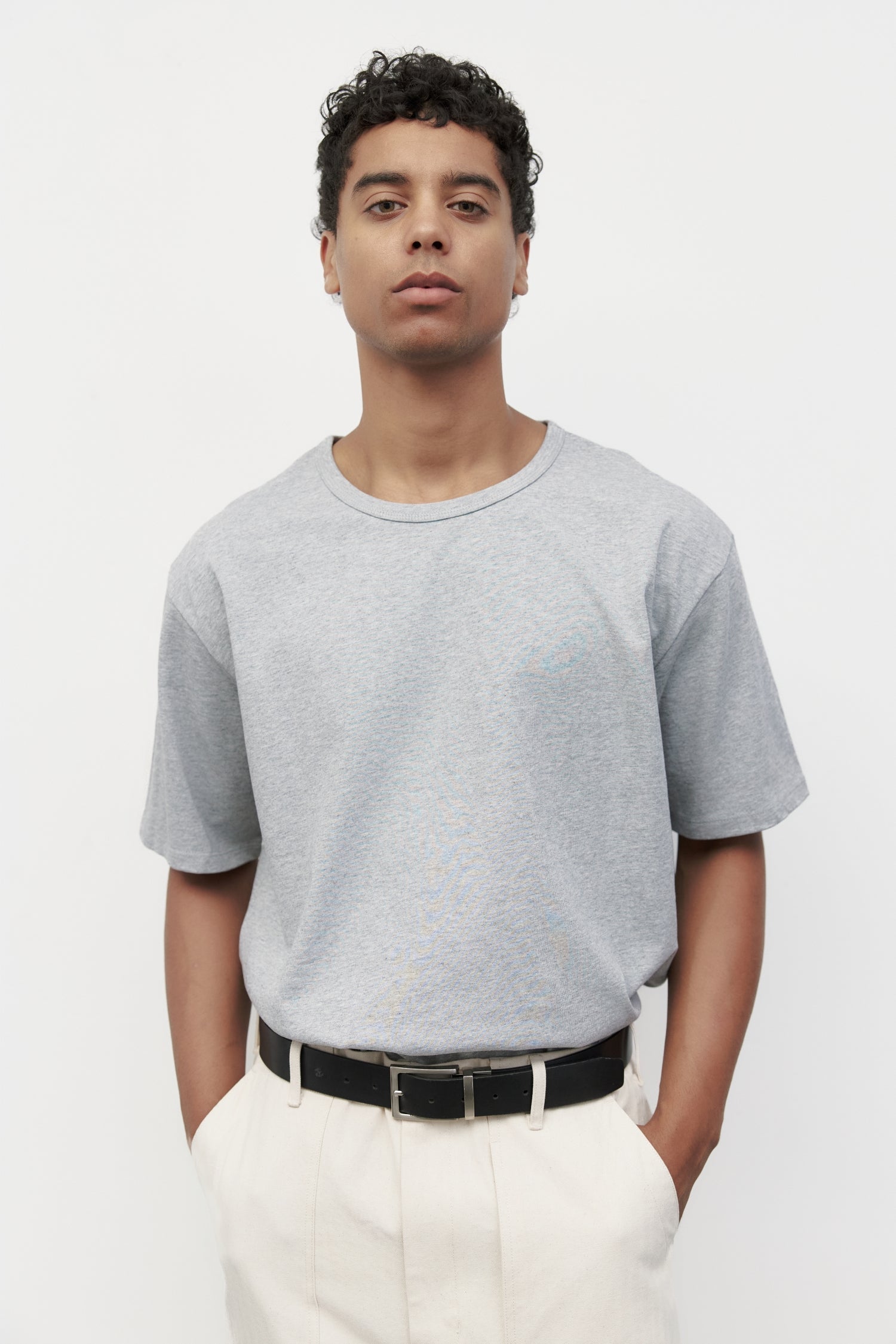 Model wearing heather grey elias top with trousers and black loafers, close up