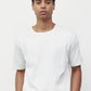 Model wearing white elias top with trousers and black loafers, close up