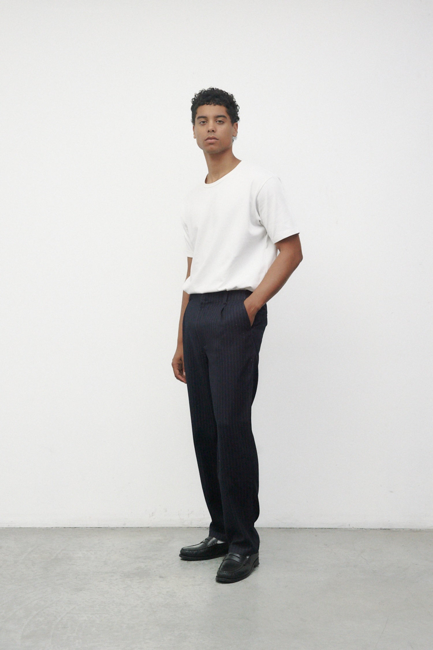 Model wearing white elias top with trousers and black loafers
