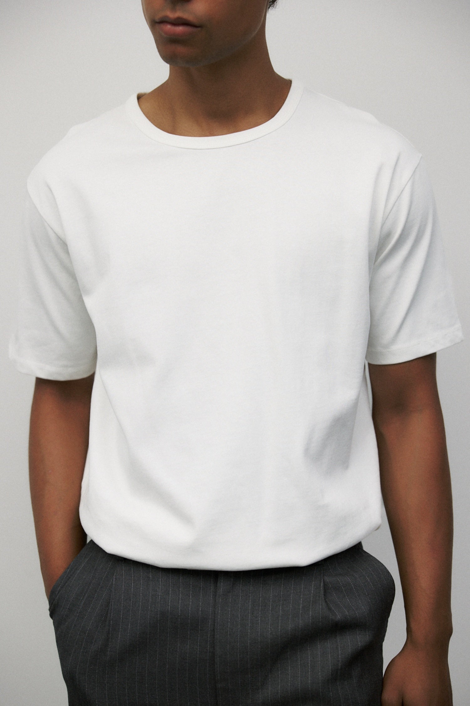 Model wearing white elias top with Grey Wayne Pants
