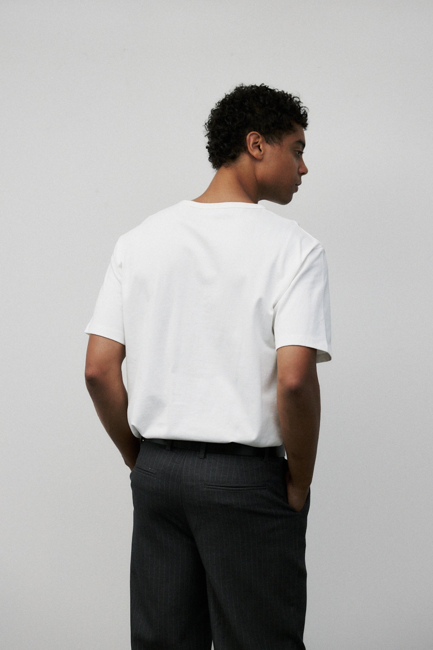 Model wearing white elias top with Grey Wayne Pants, back side